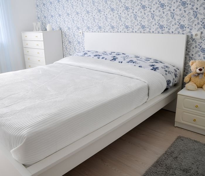 Comforters - illustrative category image | Raghuvir Lifestyle White quilted bedding on a made bed