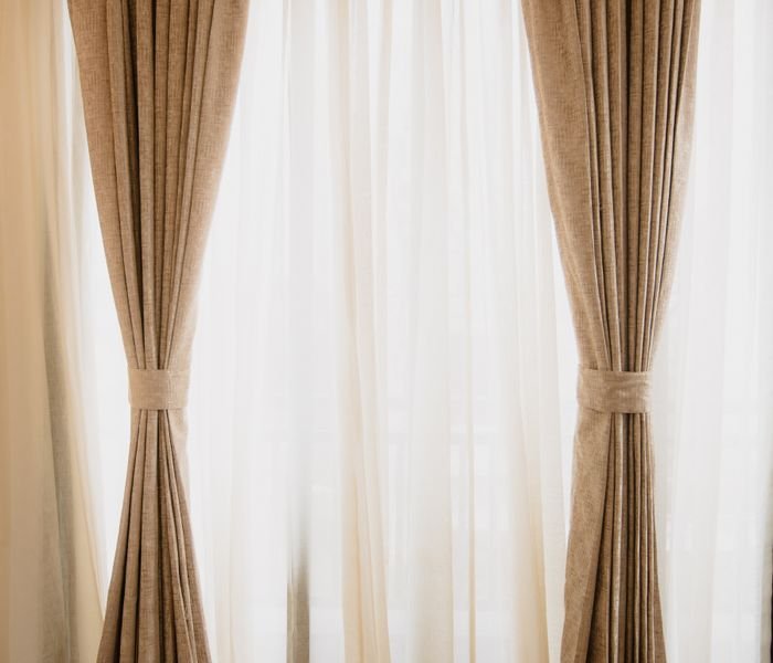 Beige curtains framing a bright window