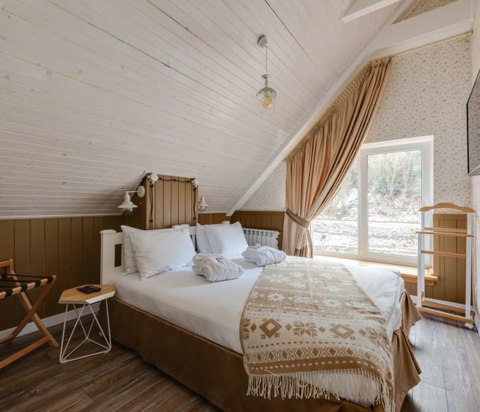 Bedroom with a made bed and patterned throw